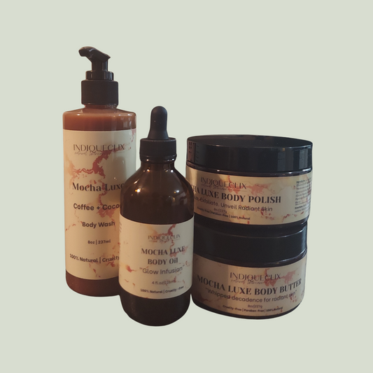 A bottle of African Black Soap body wash, a jar of Mocha Luxe body polish, a jar of Mocha Luxe body butter, and a jar of mocha luxe body oil on a light green background.